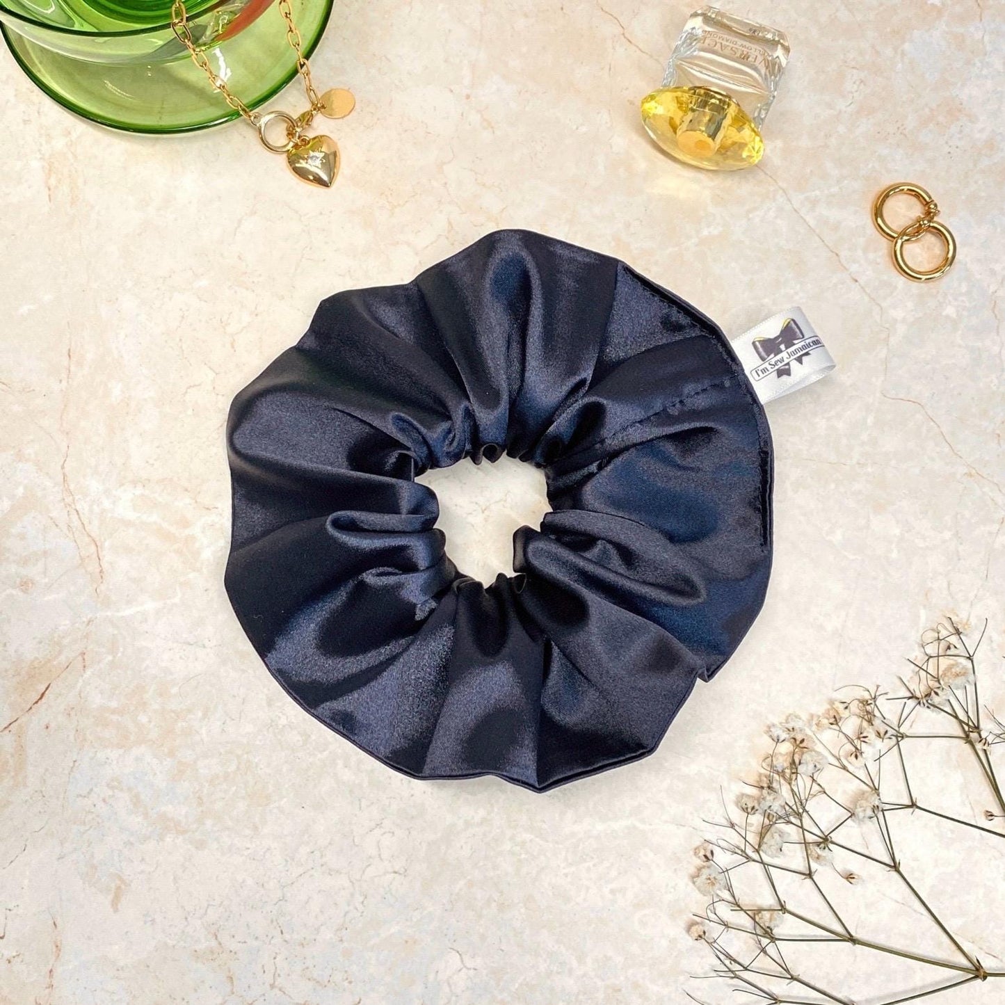 Navy blue satin hair scrunchie with shine, stylish accessory for all hair types.