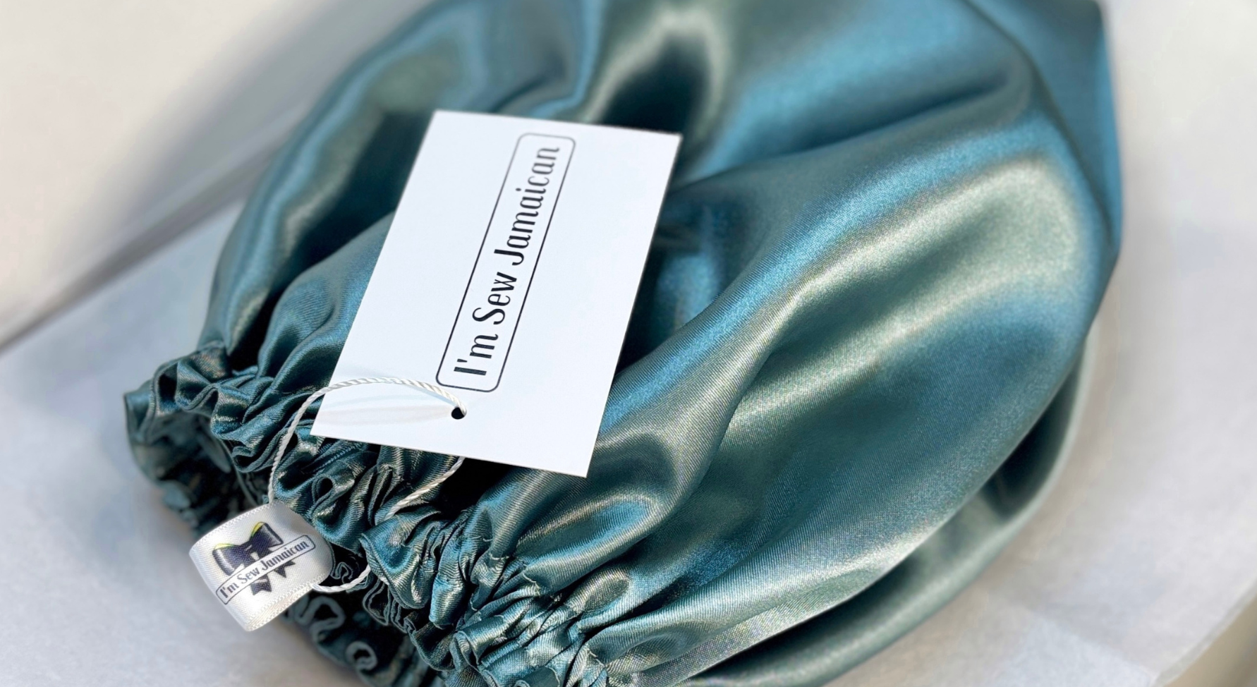 Aqua blue satin bonnet for hair protection in eco-friendly gift packaging box, perfect for preventing frizz and maintaining moisture