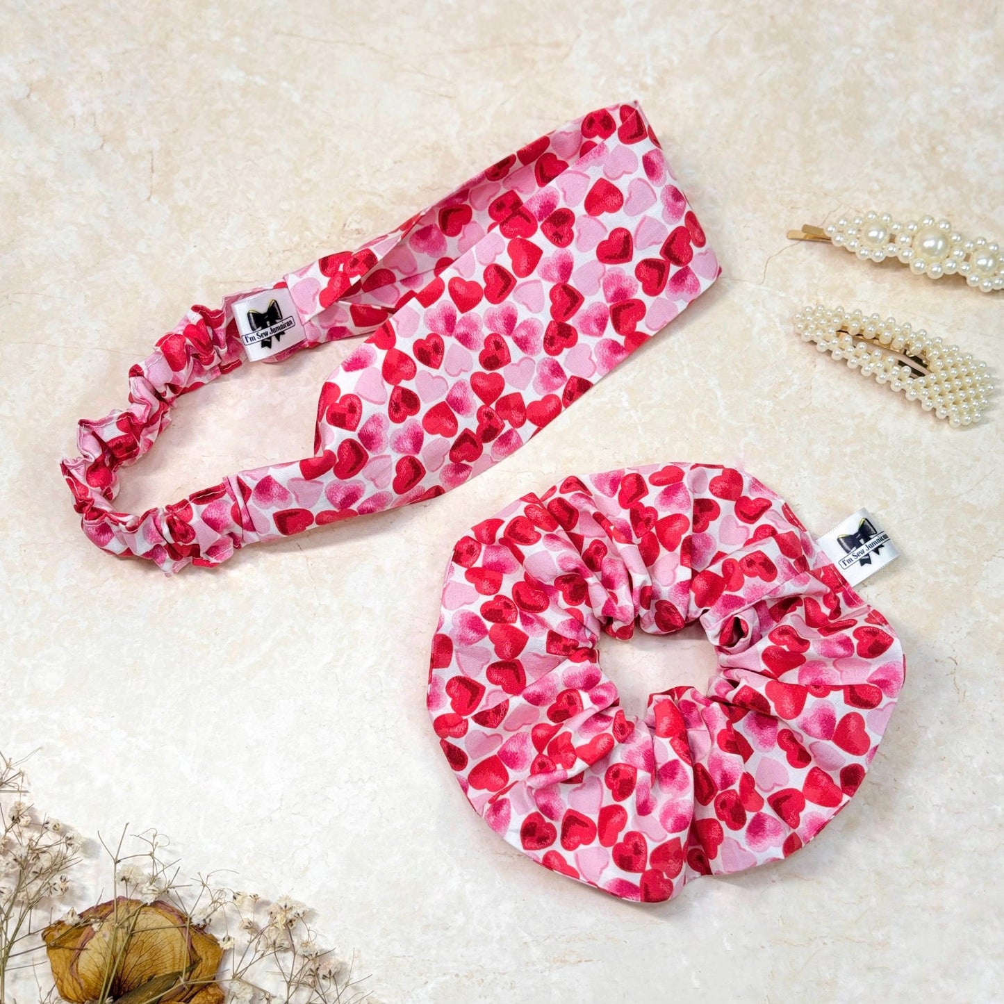 Cotton heart fabric hair scrunchie and cotton heart fabric headband on marble background.
