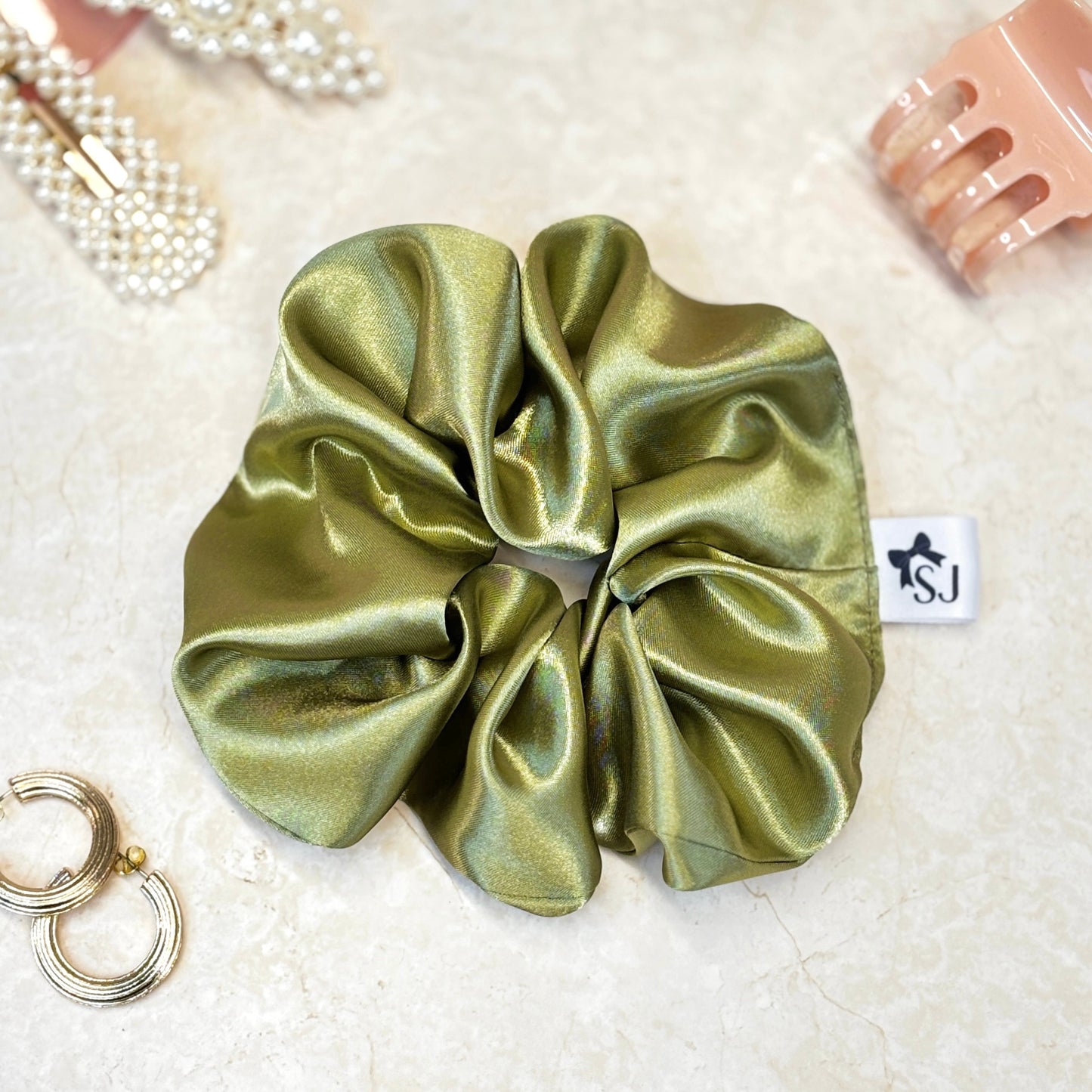 Olive green satin hair scrunchie with shine, stylish accessory for all hair types.