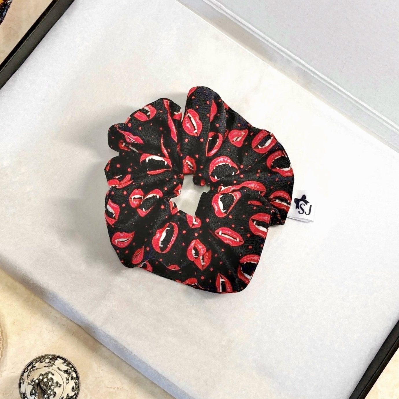 Black Halloween scrunchie with red lip pattern on a white box