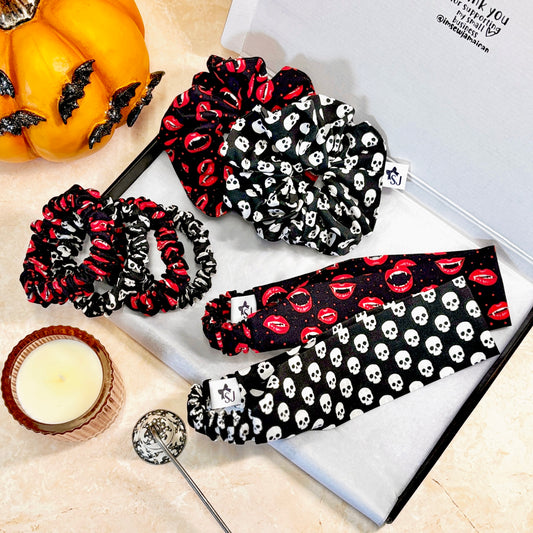 Set of Halloween-themed scrunchies and headbands on a table with decorative items.