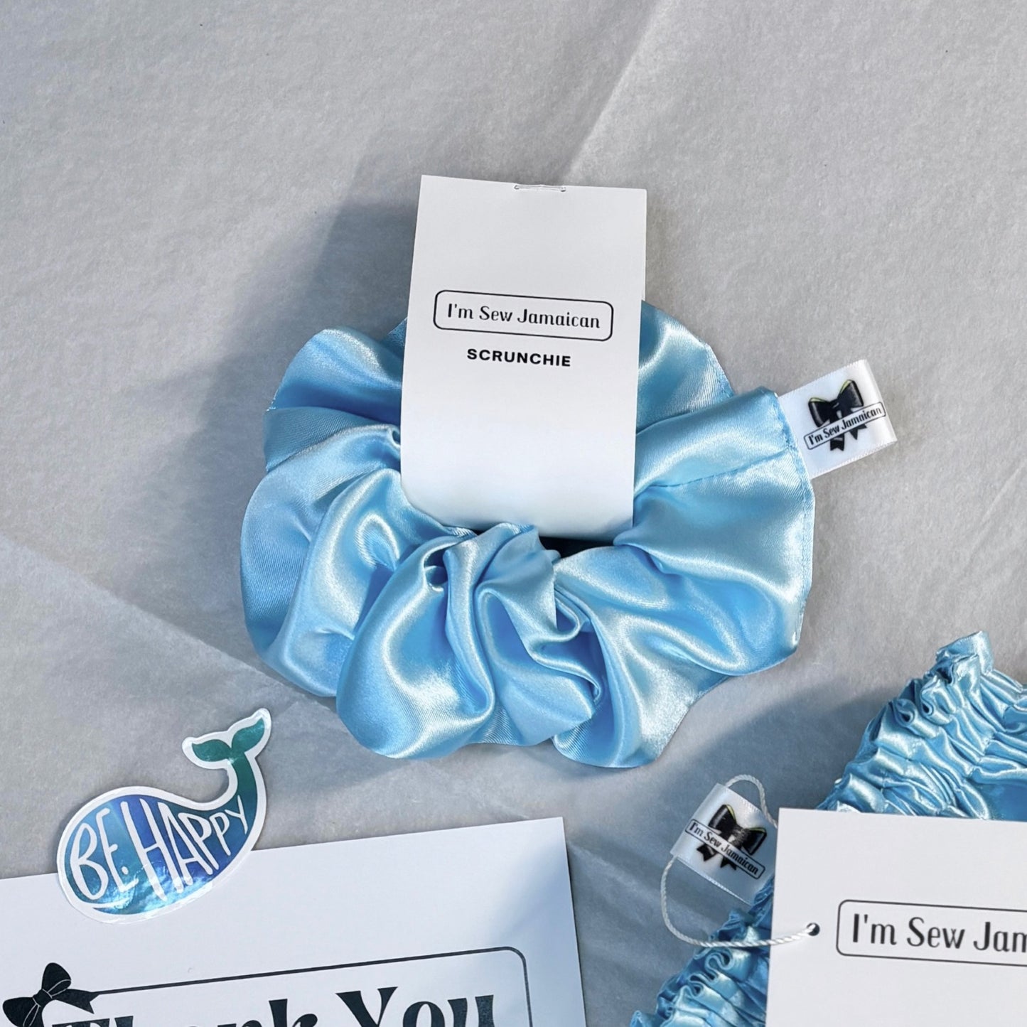 aby blue satin scrunchie with a smooth, glossy finish