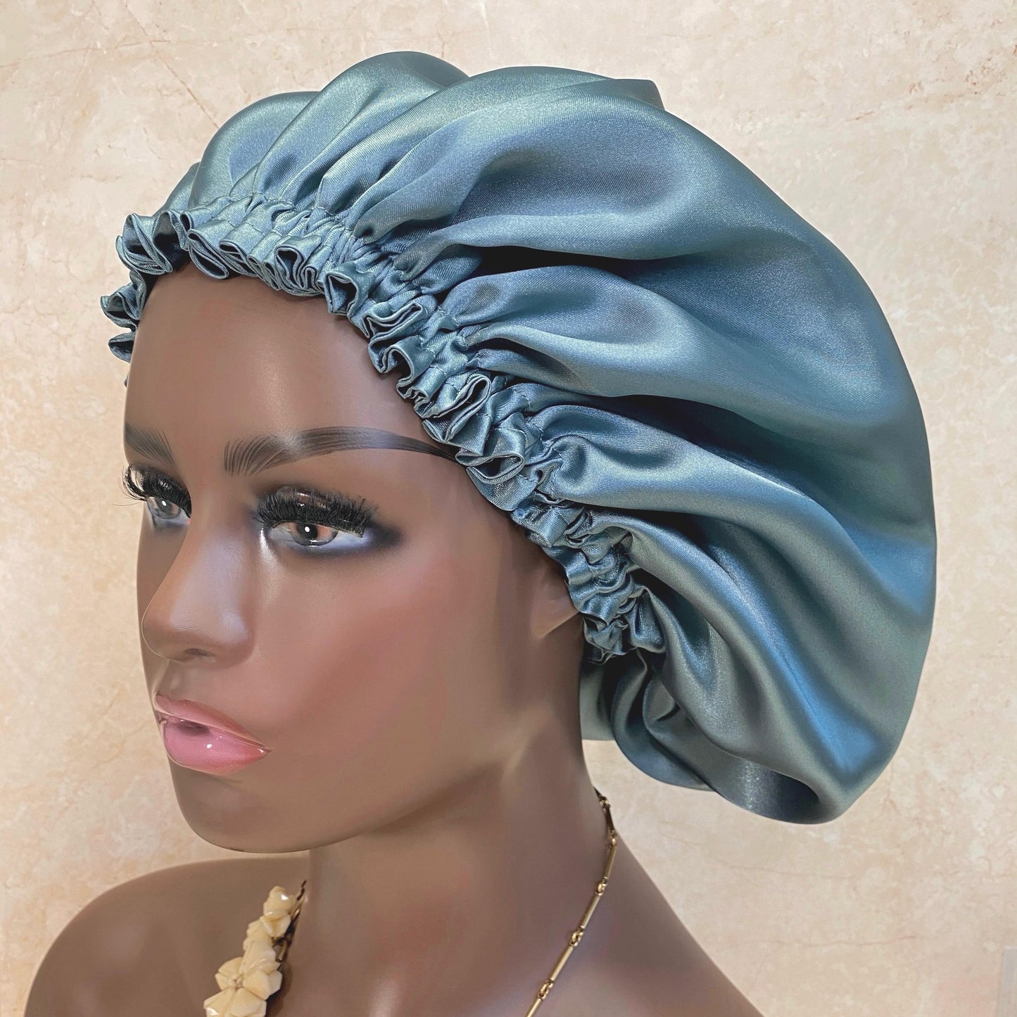 Aqua satin bonnet on a woman mannequin head, perfect for hair care, night protection, and luxury hair accessories, from a small business.
