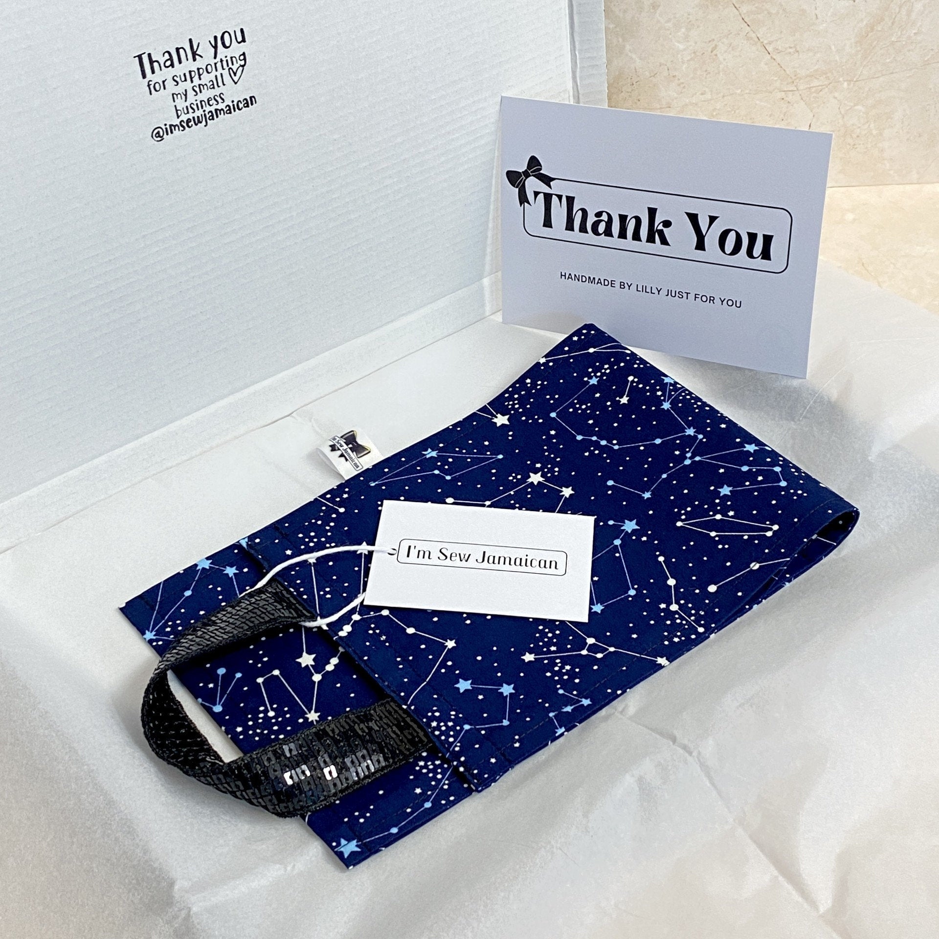 Navy blue night sky fabric toilet roll holder in a branded packaging postal box with tissue paper and thank you card.