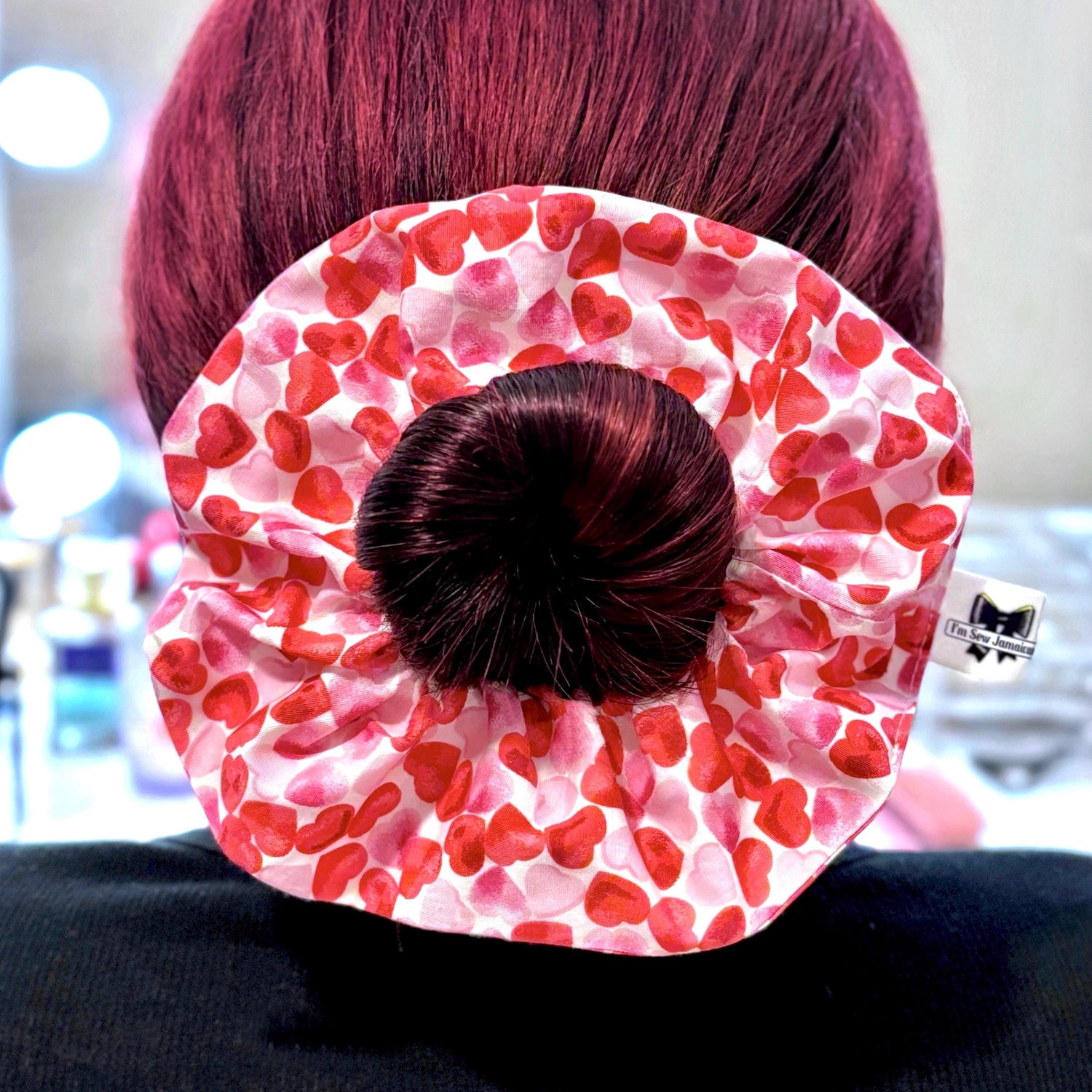 Hair styled in a cotton fabric heart scrunchie around a ponytail bun, back view.