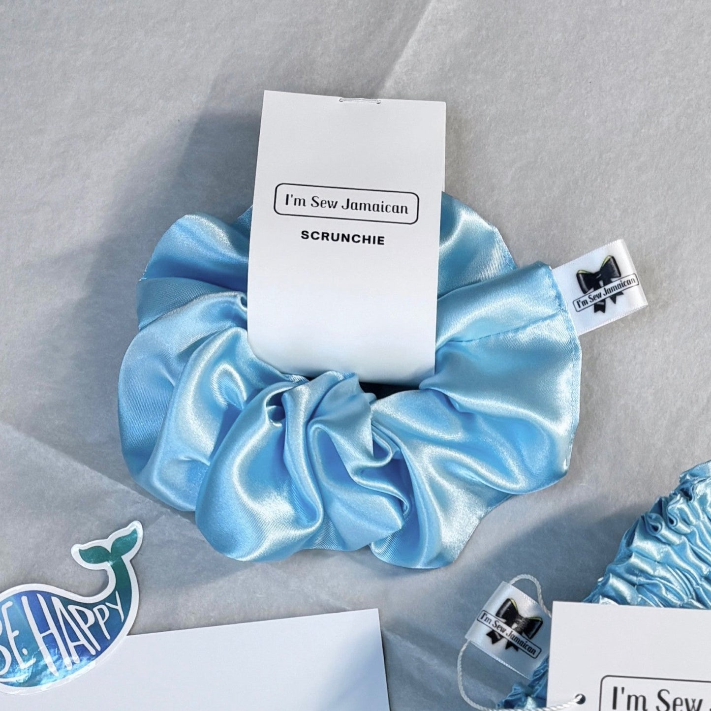 Baby blue satin scrunchie with a smooth, glossy finish