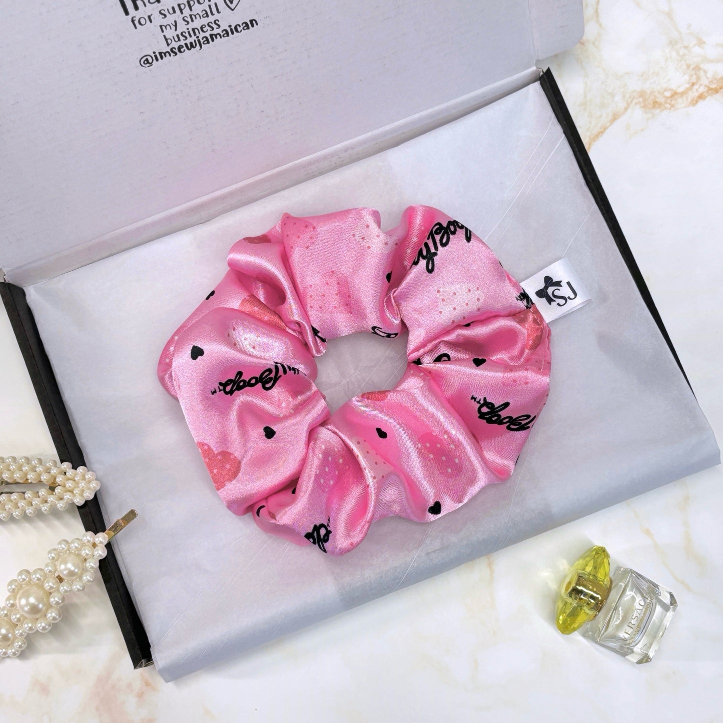 Pink Betty Boop satin scrunchie in a branded packaging postal box with tissue paper.