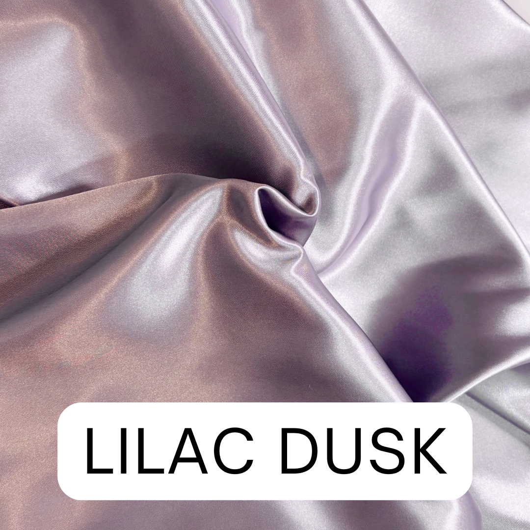 Close-up of lilac fabric with 'LILAC DUSK' for satin hair bonnet.