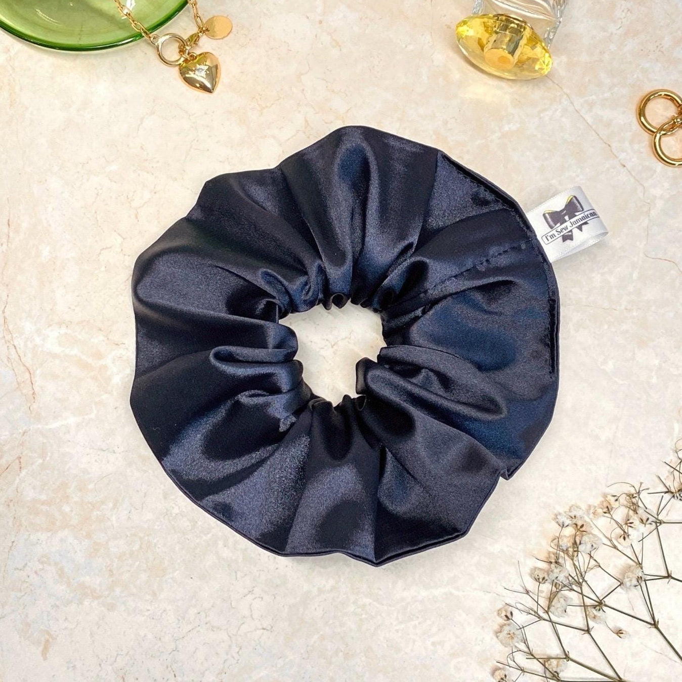 Navy blue satin hair scrunchie with shine, stylish accessory for all hair types.