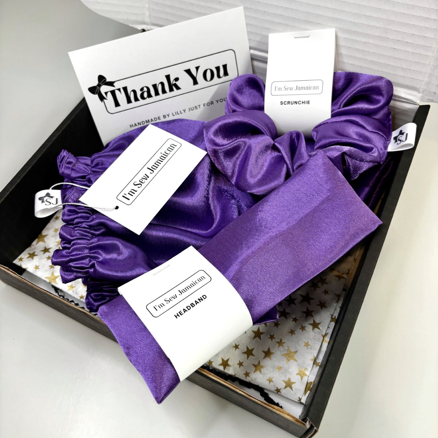 Purple satin bonnet gift set with matching scrunchie and headband in branded packaging
