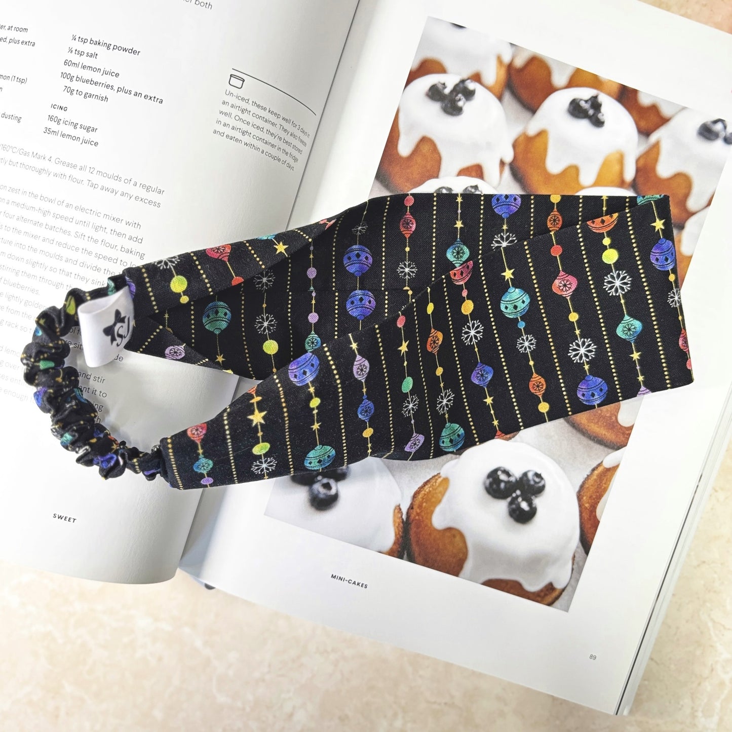 Black Christmas headband on open book with cake images background