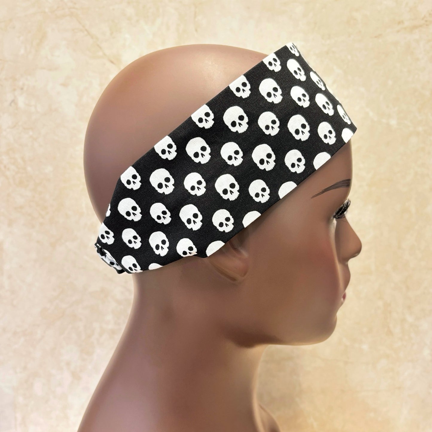 Black Halloween headband with white skull pattern worn by a mannequin 
