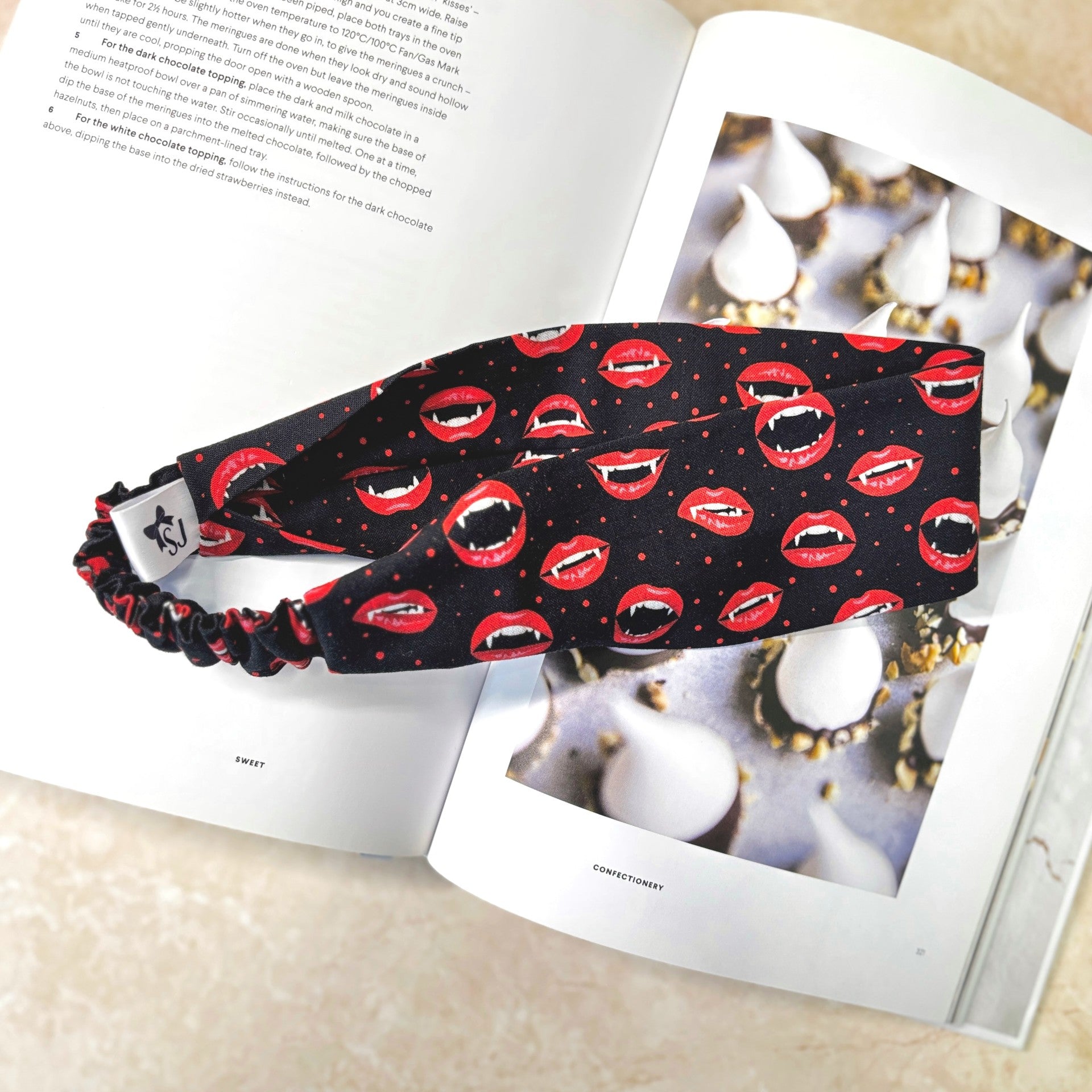 Black headband with red lip pattern on a magazine