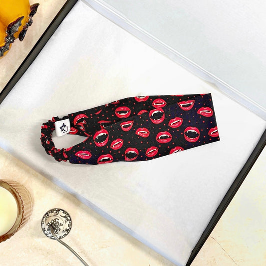 Black Halloween headband with red lip print on a white surface