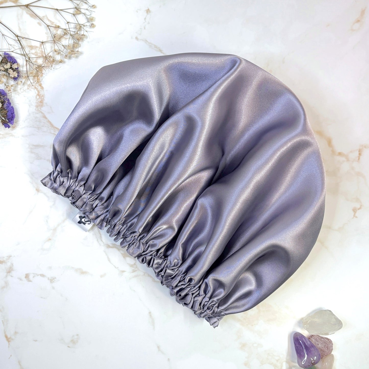 Lilac satin bonnet on plain background