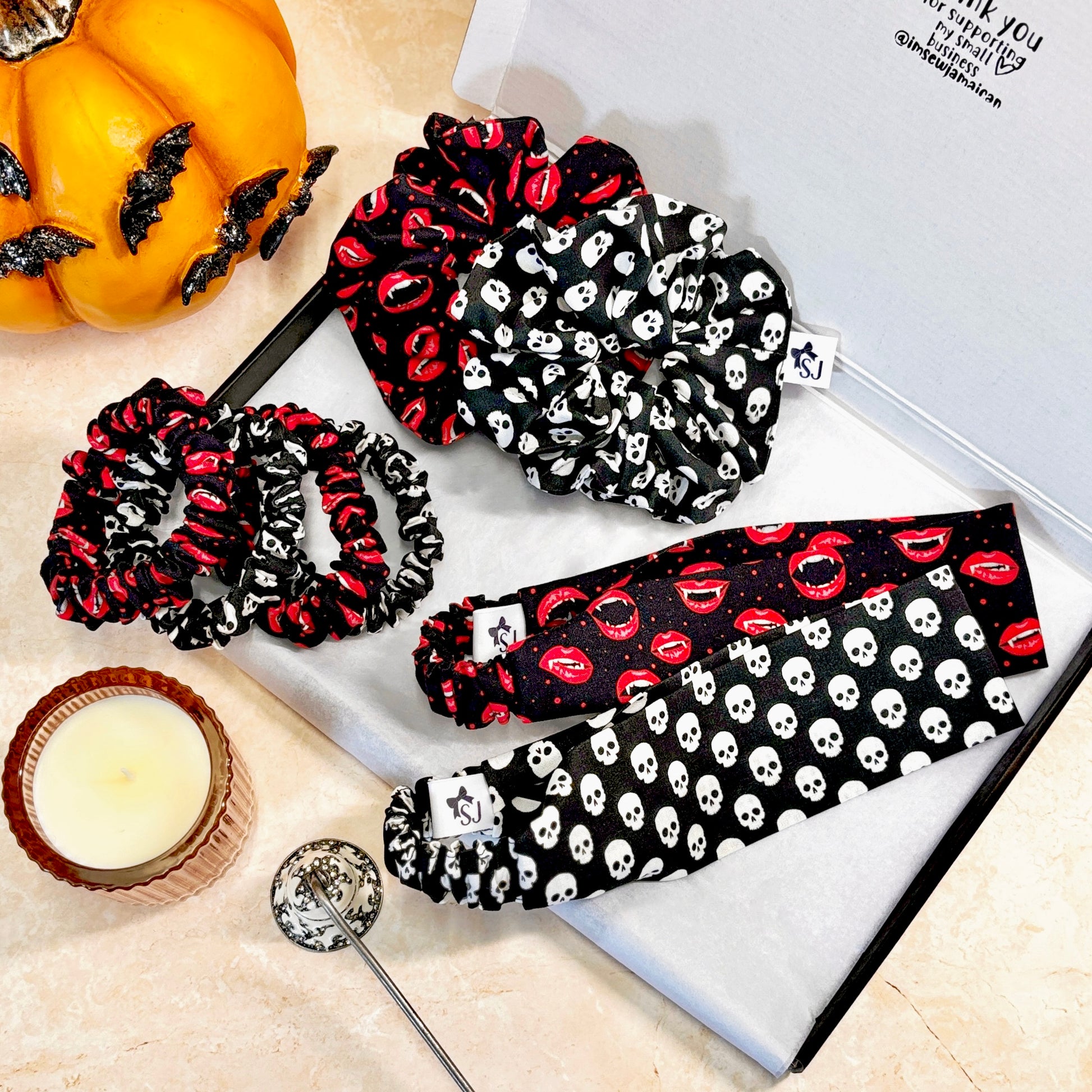 Set of Halloween-themed scrunchies and headbands on a table with decorative items.
