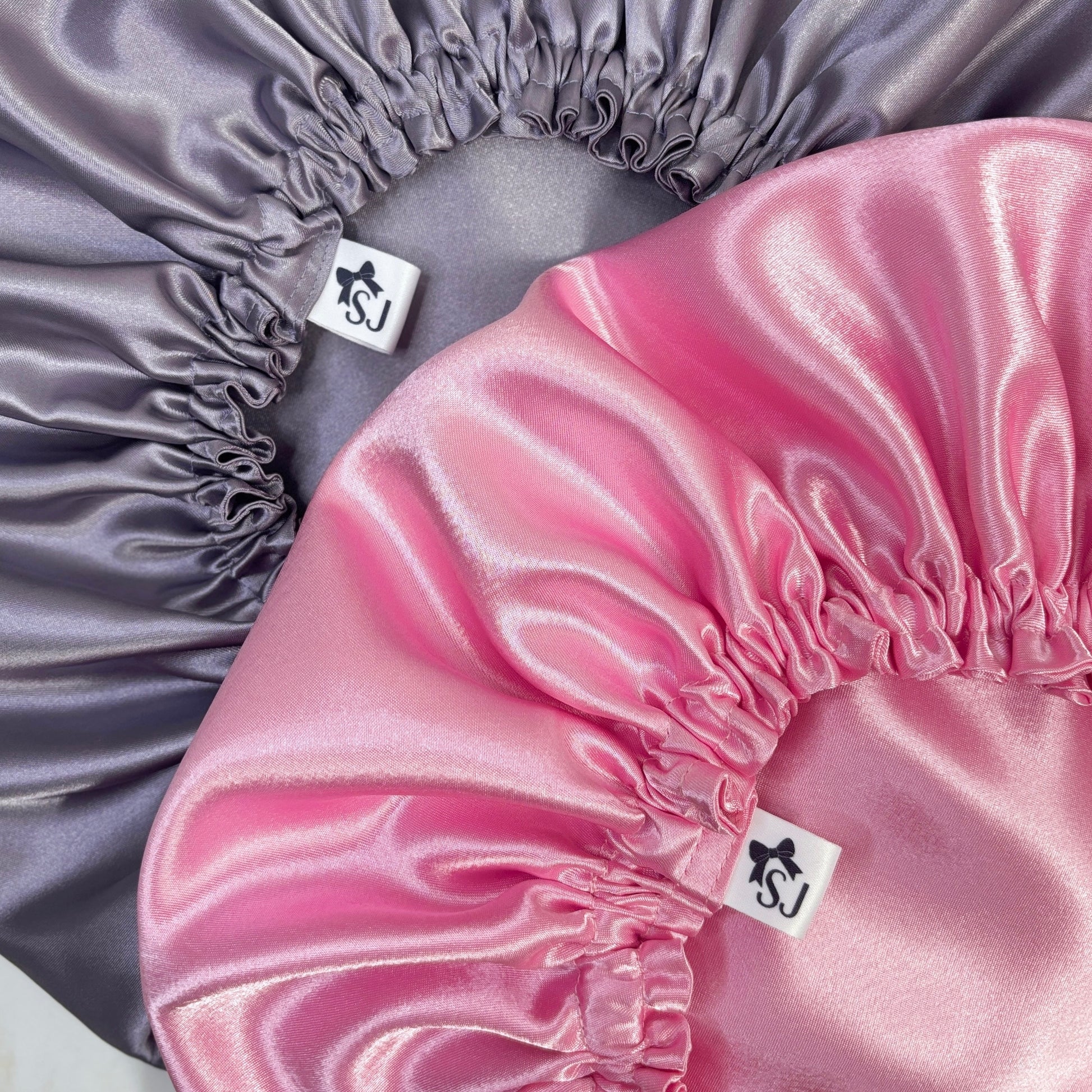 lilac satin bonnet and pink satin bonnet close up photo