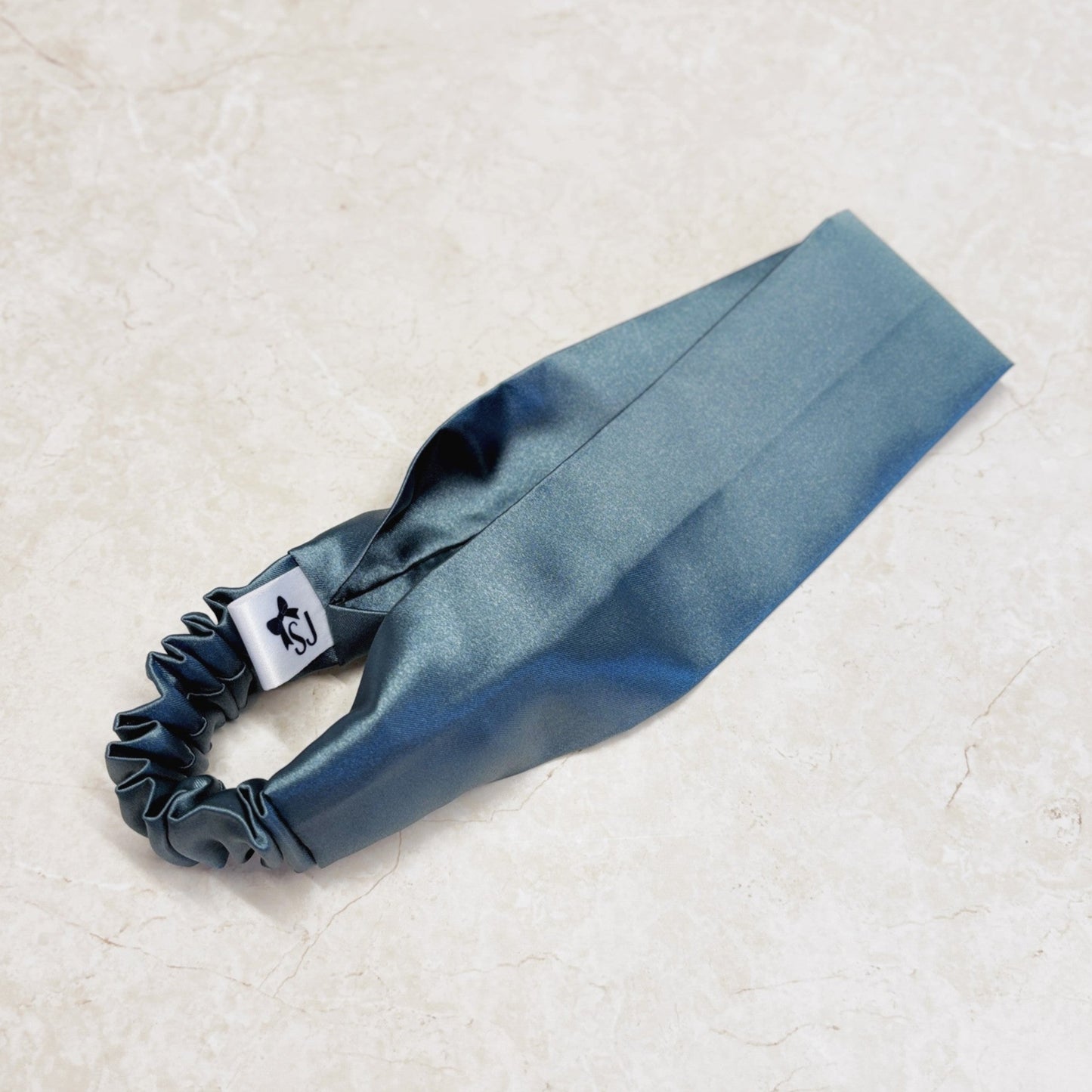 Aqua satin headband with a thick, wide top and elastic back