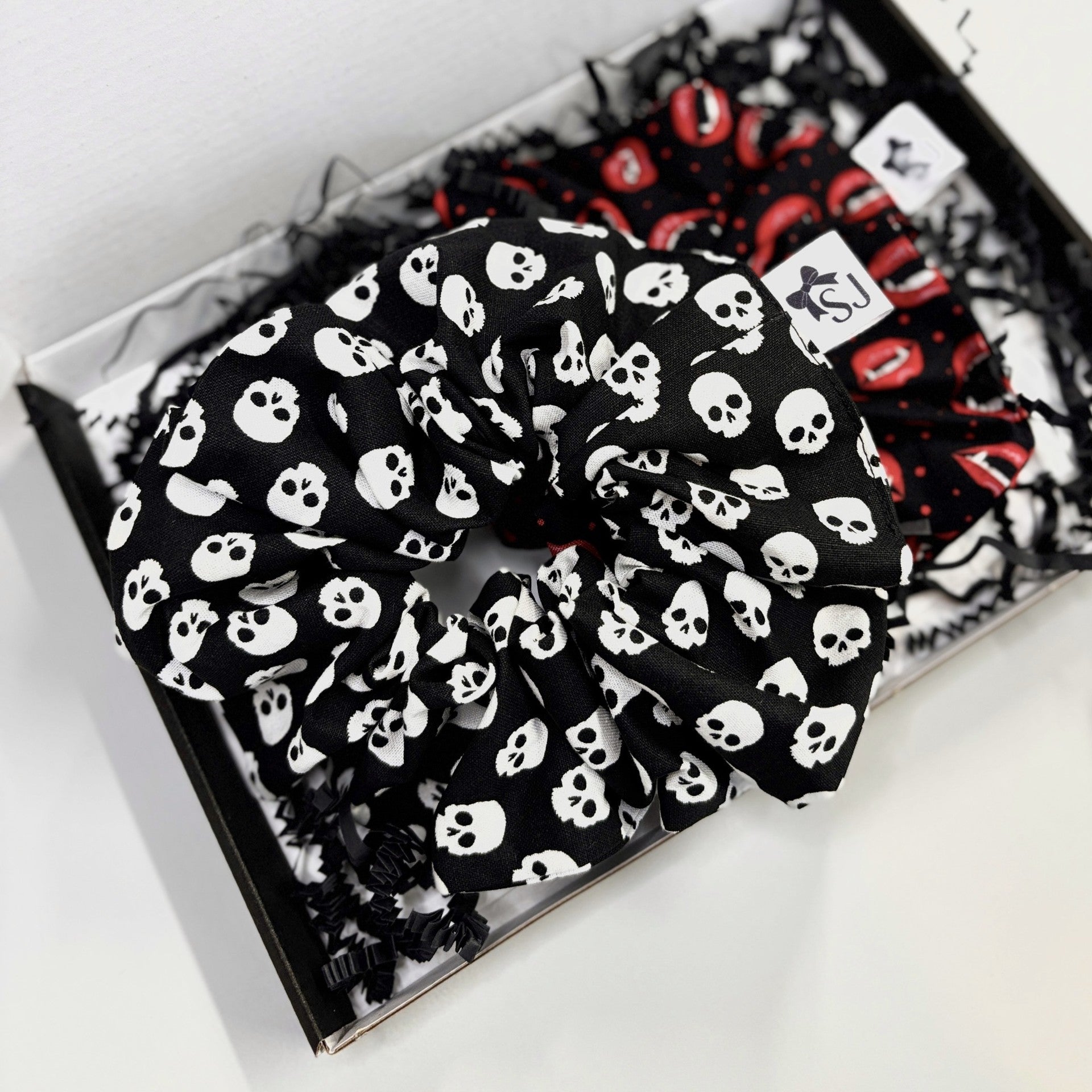 Halloween scrunchie with black and white skulls in shipping packaging
